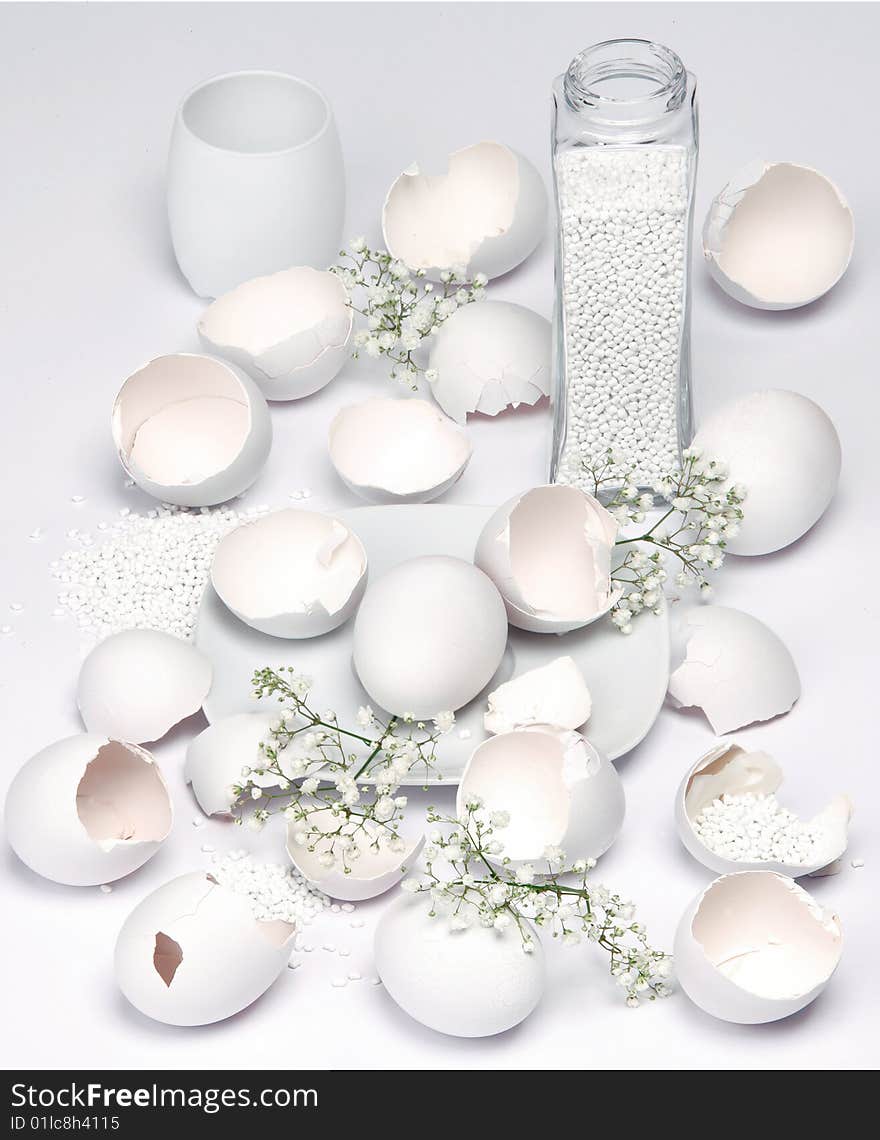 Broken white eggs on white background