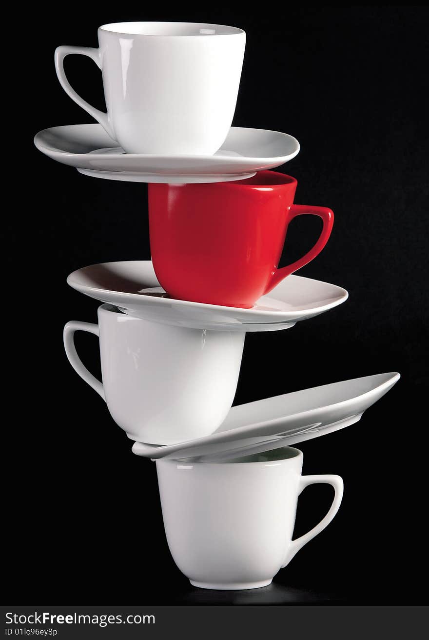 White cups and saucers on black background