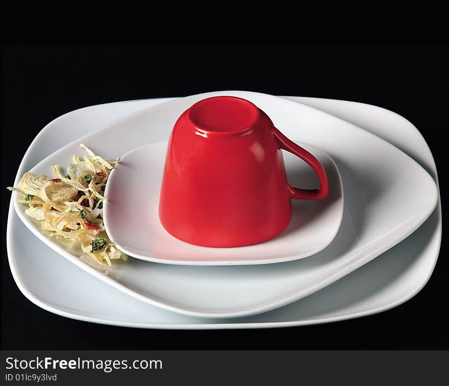 Red cup on white saucer on black background