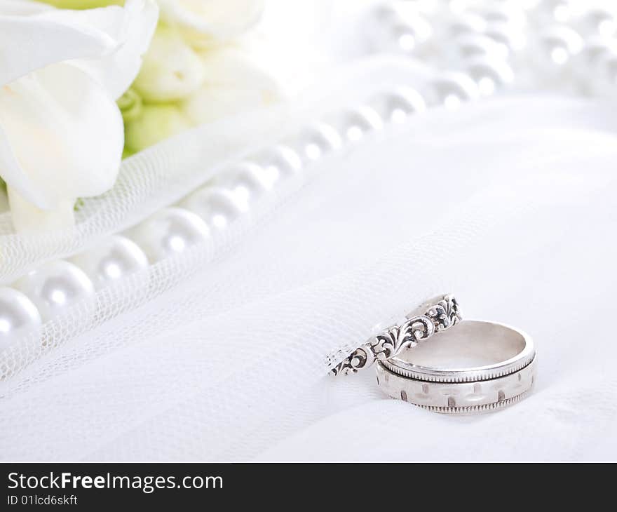 Closeup of wedding rings on a white veil