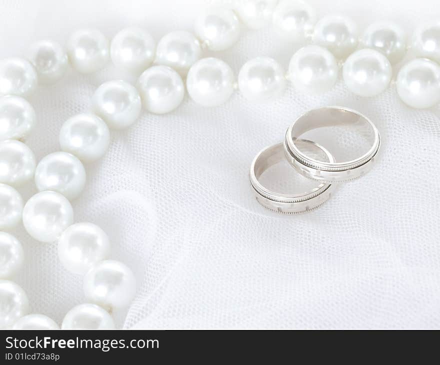 Closeup of wedding rings on a white veil