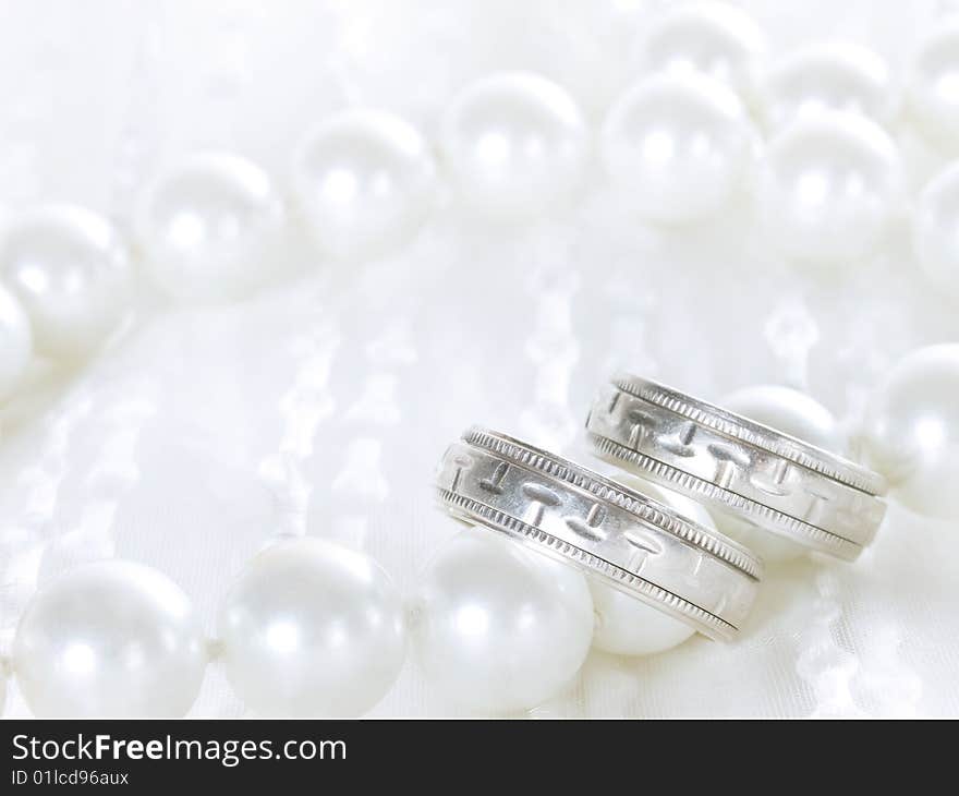 Closeup of wedding rings on a white veil