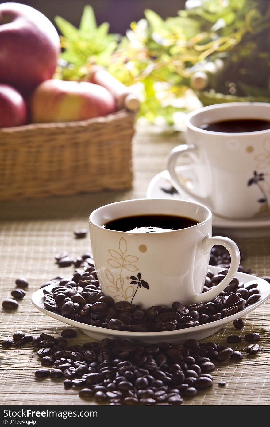 Cup of coffee and beans closeup on table