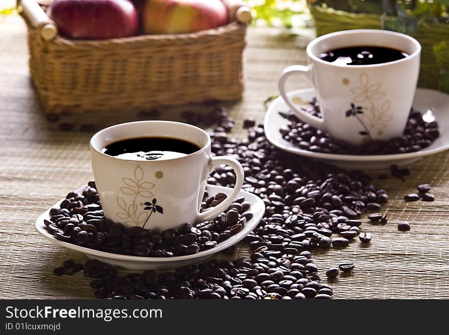 Cup of coffee and beans closeup on table