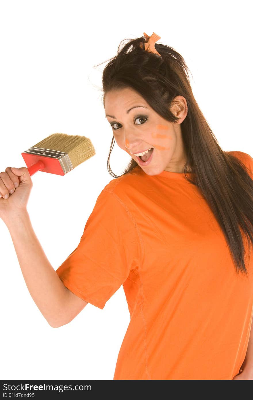 Young caucasian brunette holding a brush with orange t-shirt and orange paint on her face,making facial expression. Young caucasian brunette holding a brush with orange t-shirt and orange paint on her face,making facial expression