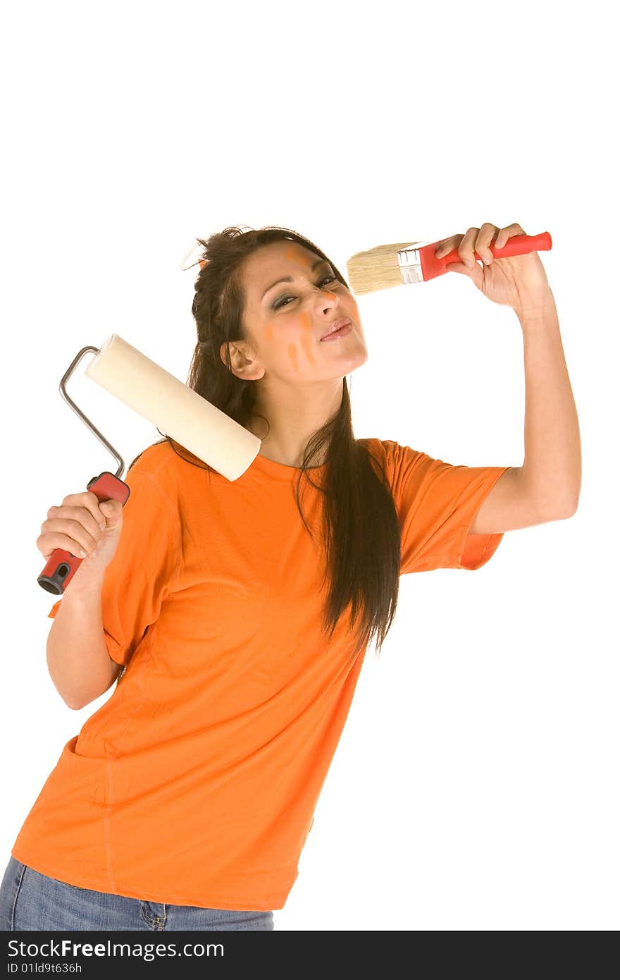 Young caucasian brunette holding a brush with orange t-shirt and orange paint on her face,making facial expression. Young caucasian brunette holding a brush with orange t-shirt and orange paint on her face,making facial expression