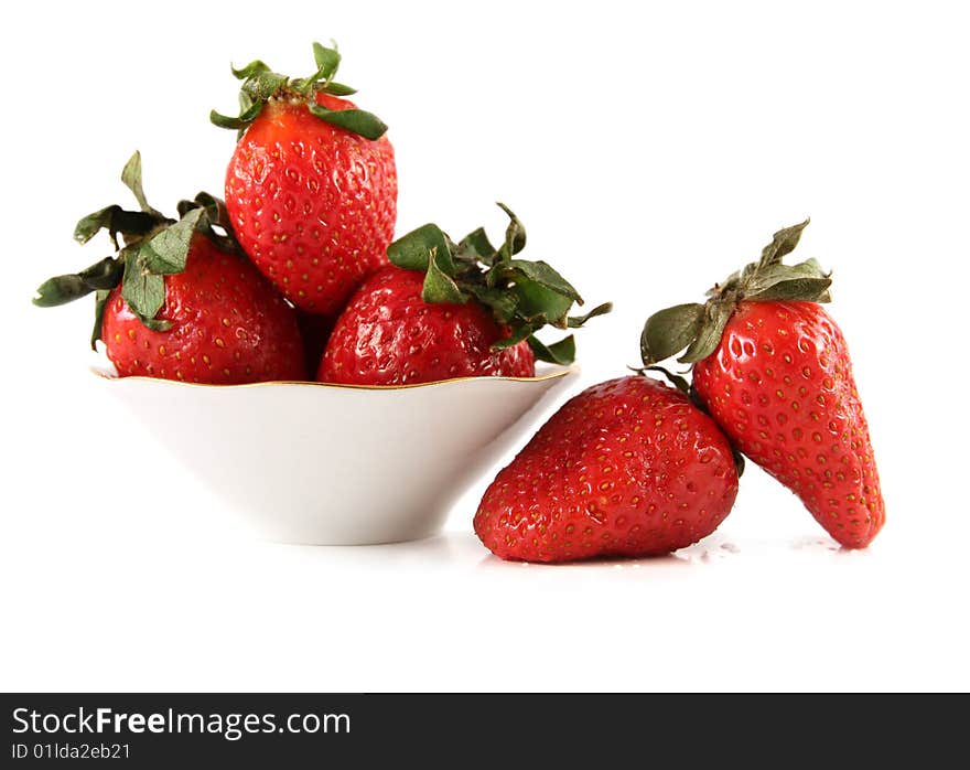 Fresh strawberry in a white saucer and near it