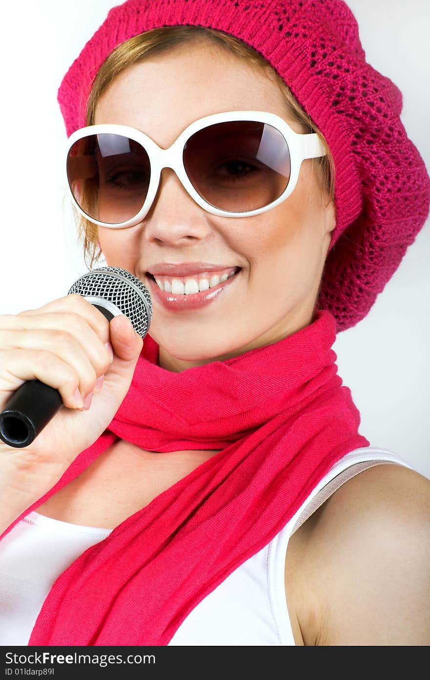 Portrait of a happy singing woman with a microphone and sunglasses. Portrait of a happy singing woman with a microphone and sunglasses