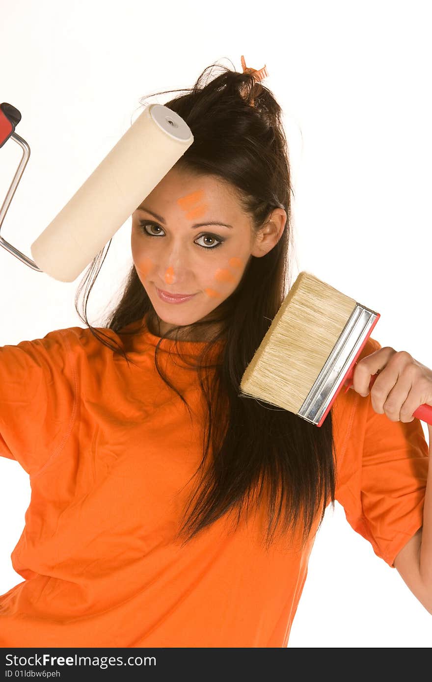 Young caucasian brunette holding a brush with orange t-shirt and orange paint on her face,making facial expression. Young caucasian brunette holding a brush with orange t-shirt and orange paint on her face,making facial expression