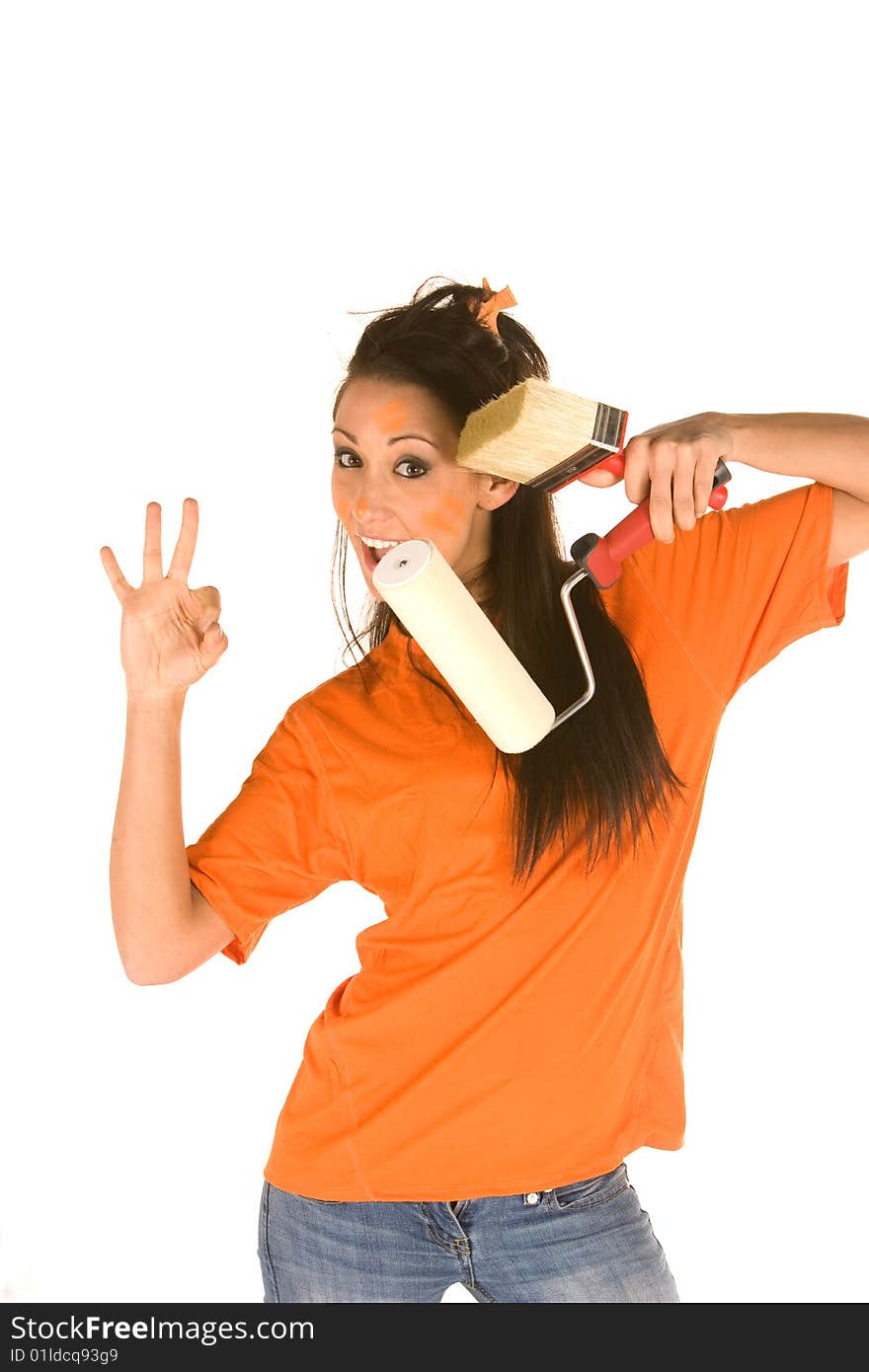 Young caucasian brunette holding a brush with orange t-shirt and orange paint on her face,making facial expression. Young caucasian brunette holding a brush with orange t-shirt and orange paint on her face,making facial expression