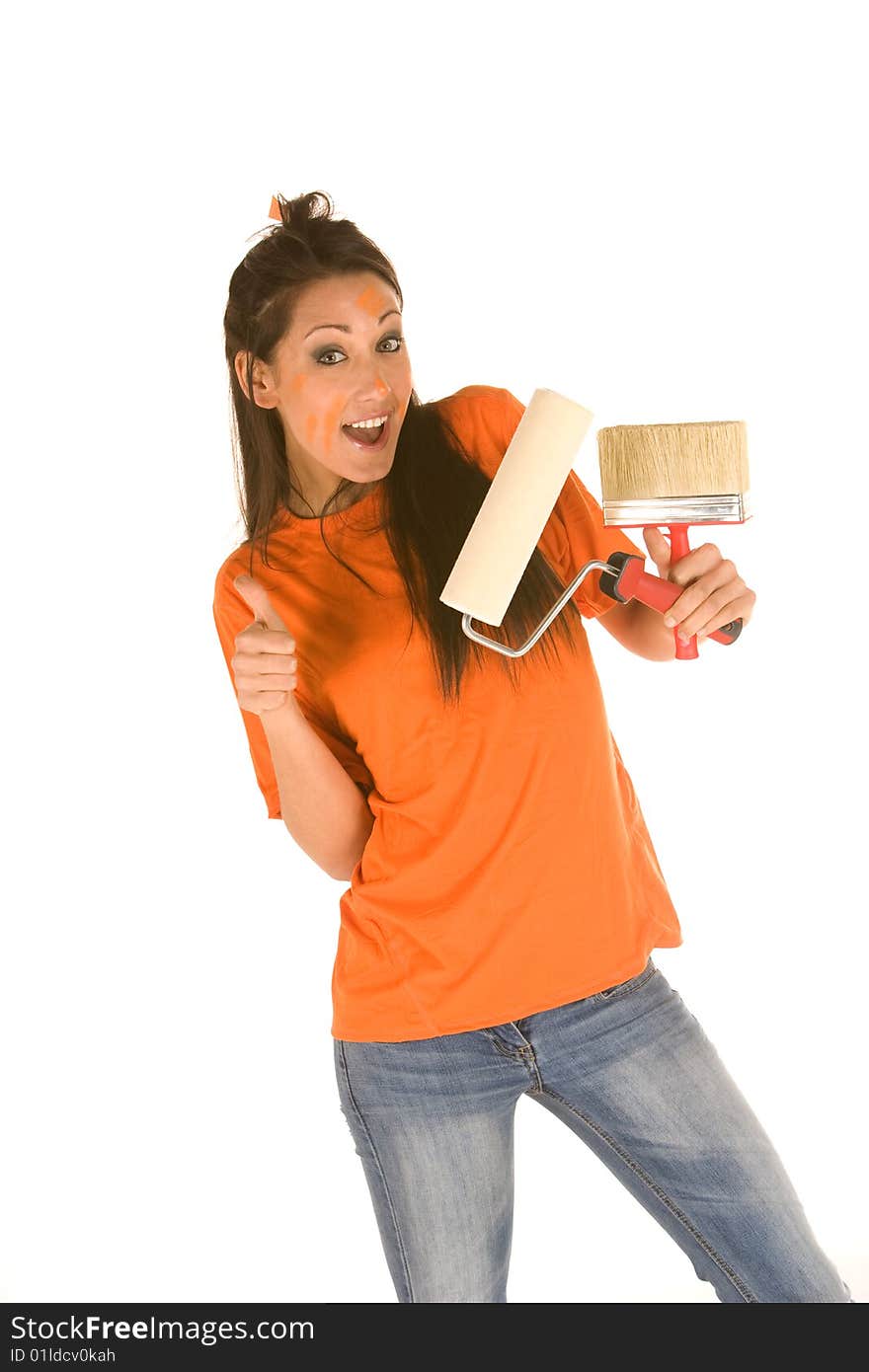 Young caucasian brunette holding a brush with orange t-shirt and orange paint on her face,making facial expression. Young caucasian brunette holding a brush with orange t-shirt and orange paint on her face,making facial expression