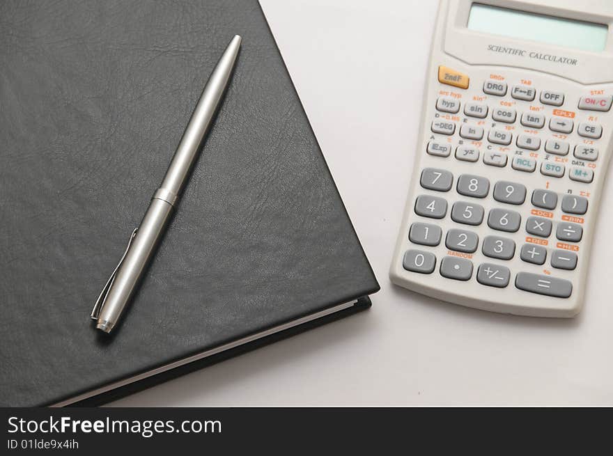 Scientific calculator next to elegant silver pen on spiral notebook. Scientific calculator next to elegant silver pen on spiral notebook