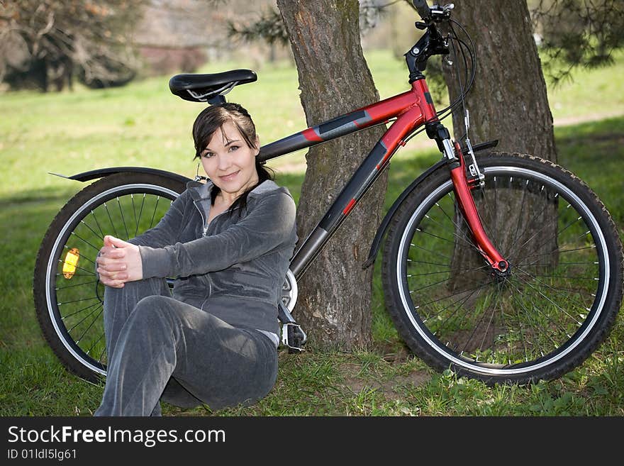 Happy woman with bike in park. Happy woman with bike in park