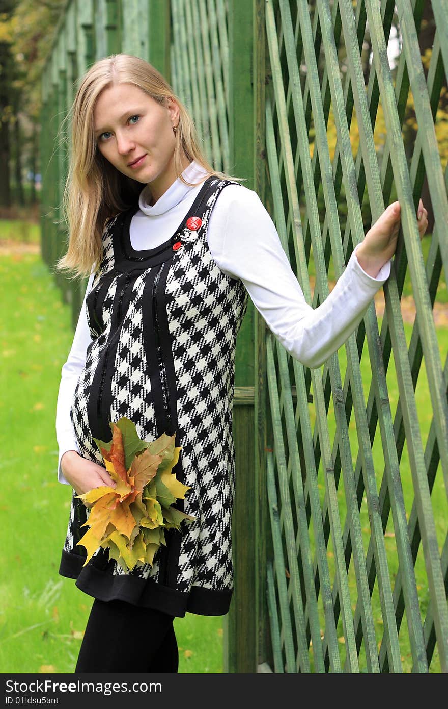 Young beautiful pregnant woman with leaves