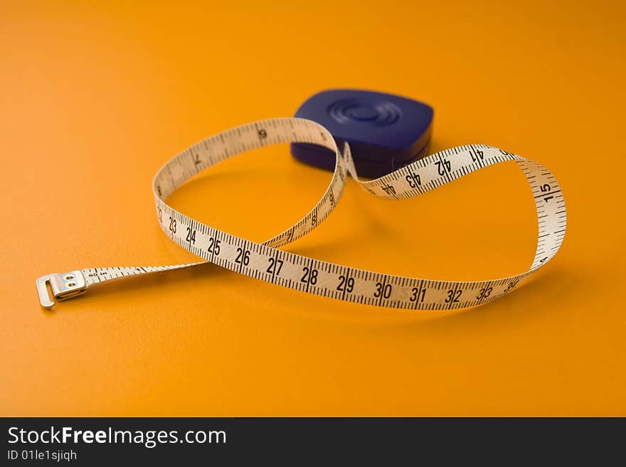 Tape measure isolated on a orange background