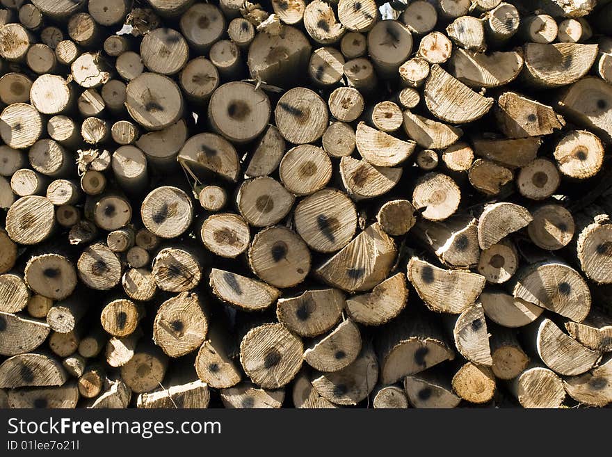 Pile of coniferous tree fire-wood close-up background. Pile of coniferous tree fire-wood close-up background