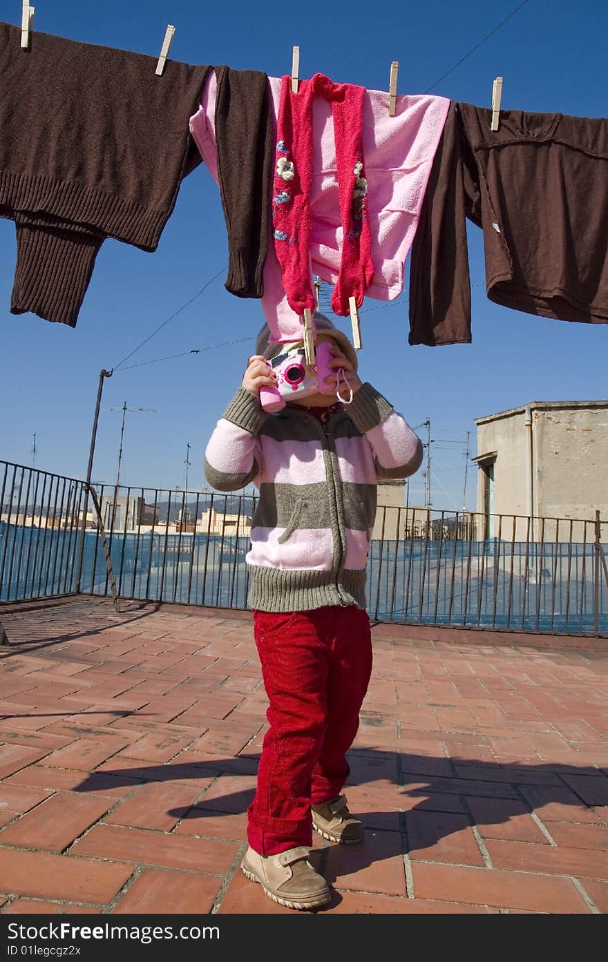 Sweet girl with pink digital camera and clothesline. Sweet girl with pink digital camera and clothesline