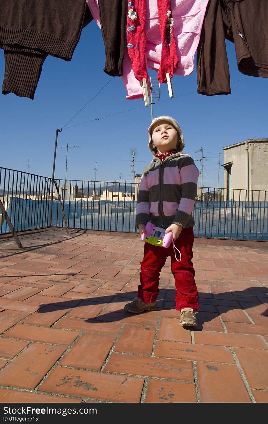 Sweet girl with pink digital camera and clothesline. Sweet girl with pink digital camera and clothesline