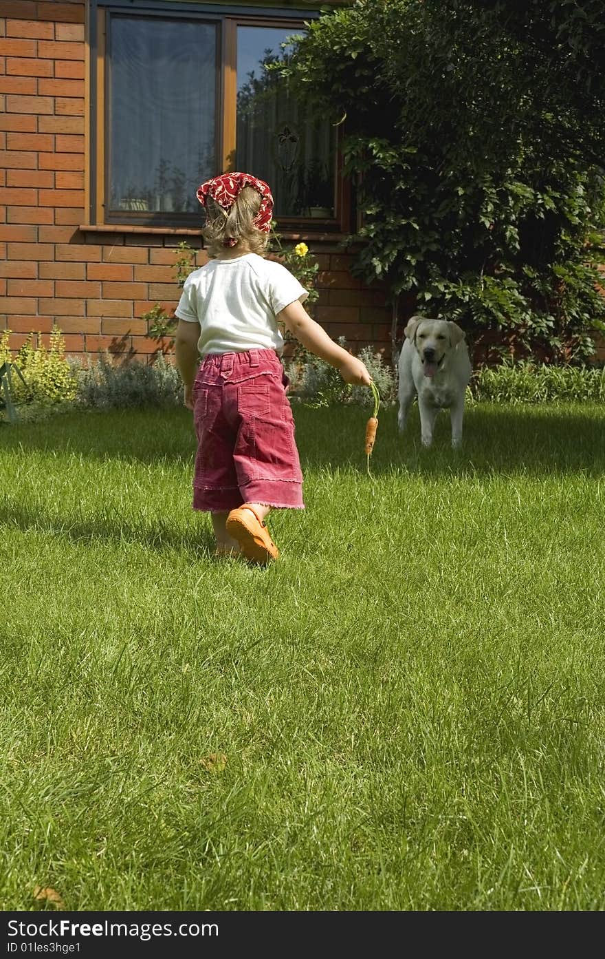 Garden. little girl with best friend and carrot