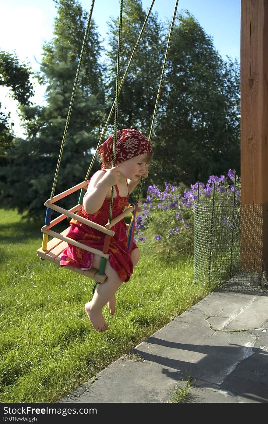 Sweet girl on a swing in a garden. summertime. Sweet girl on a swing in a garden. summertime