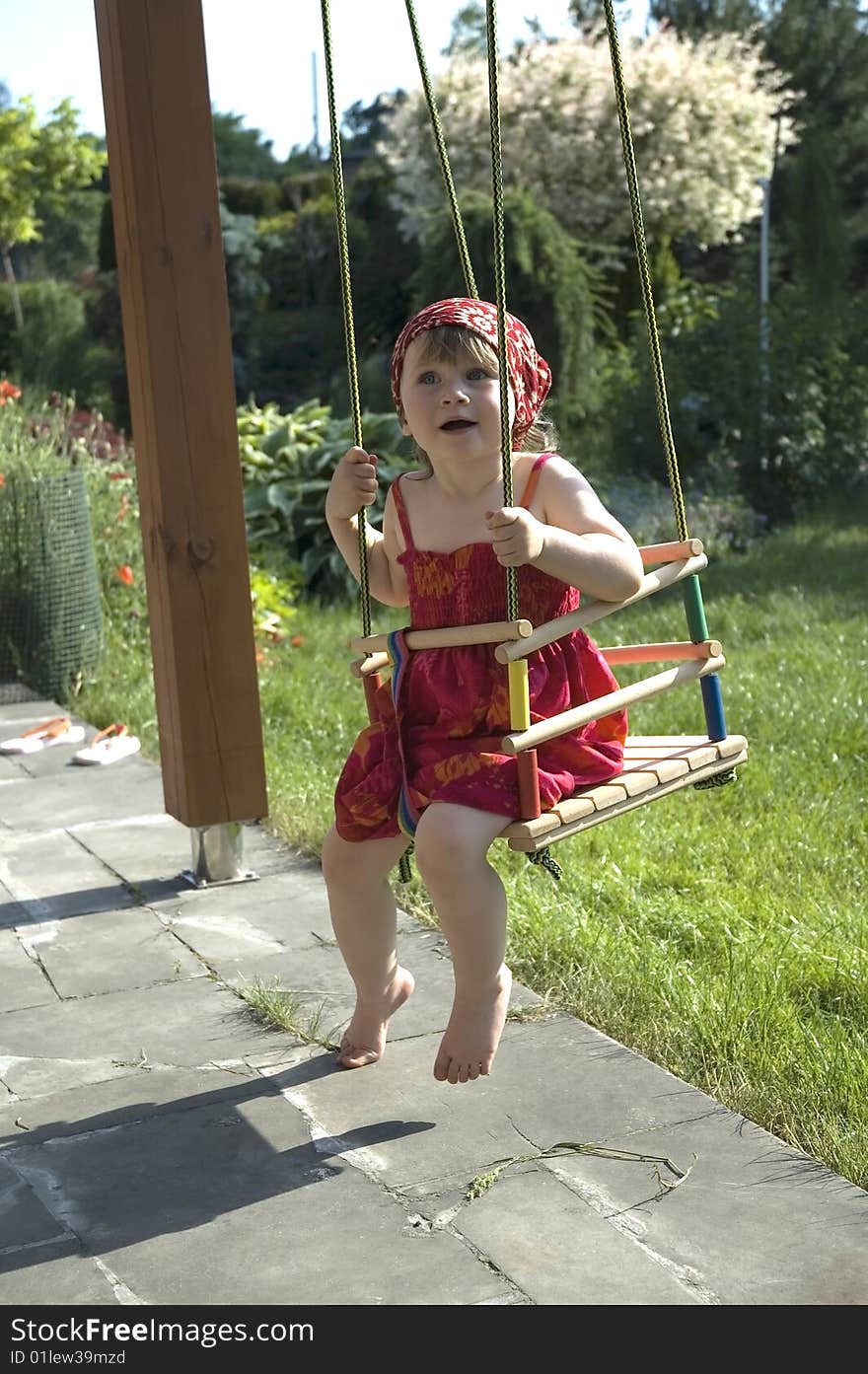 Sweet girl on a swing in a garden. summertime. Sweet girl on a swing in a garden. summertime