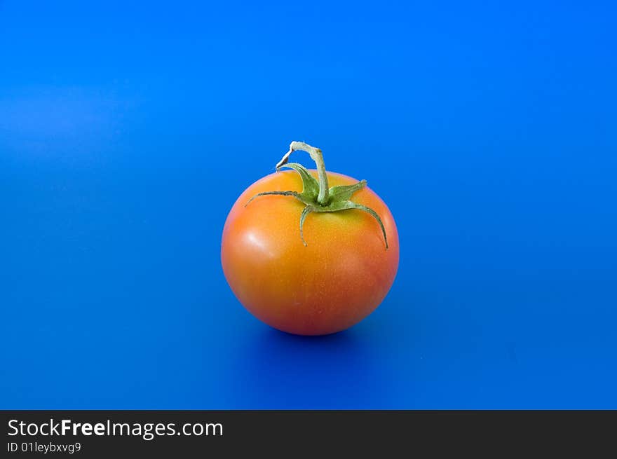 Close up of red ripe tomatoe against the blue background