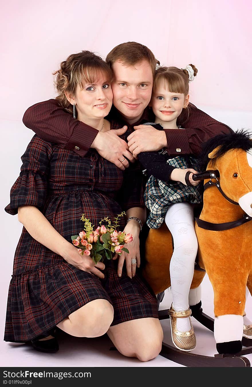 Portrait of a young family. The daddy, mum and a daughter wait for the second child. New images every week