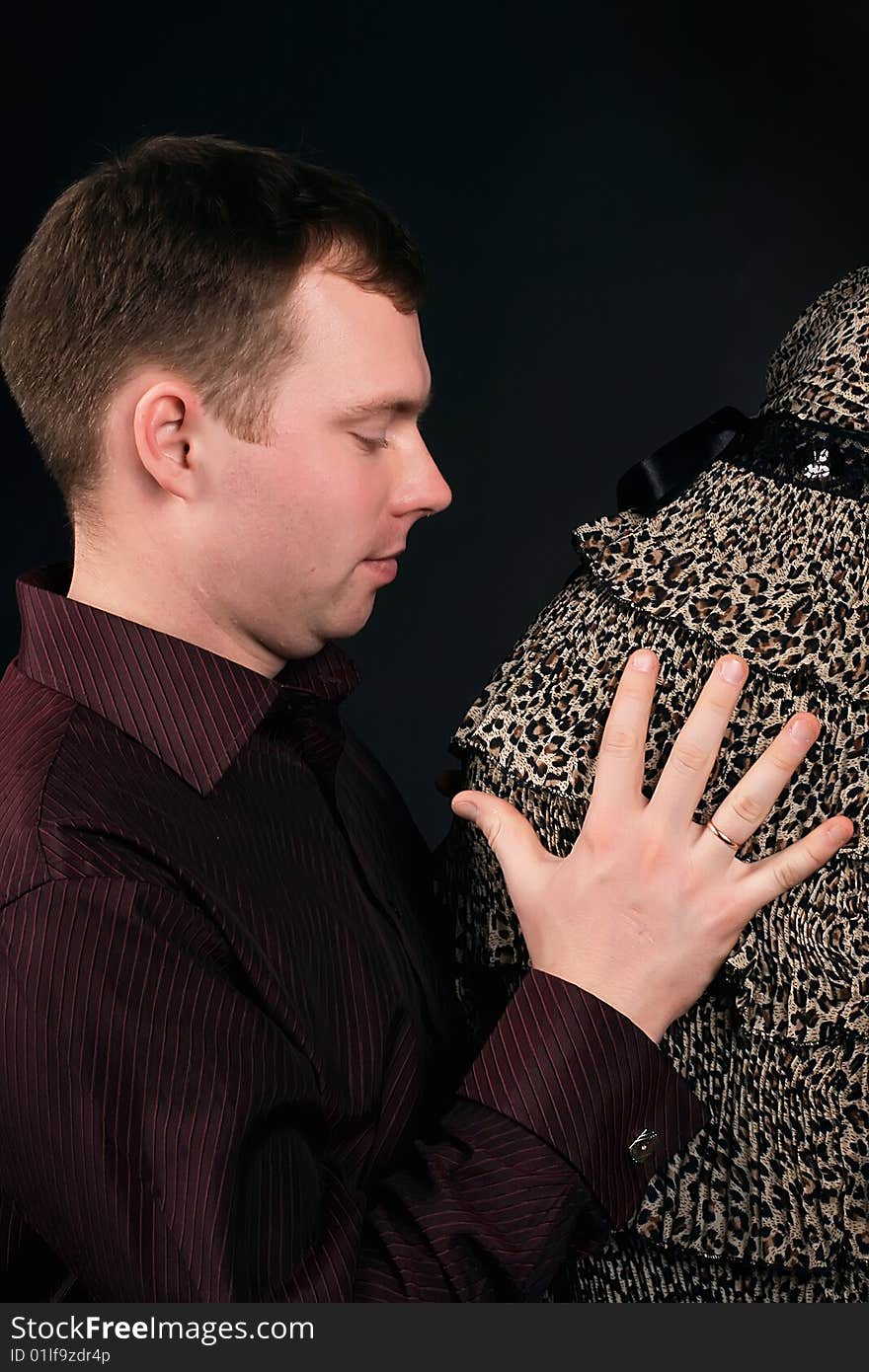 Young beautiful married couple the birth of the second child wait. Dark background. New photos every week