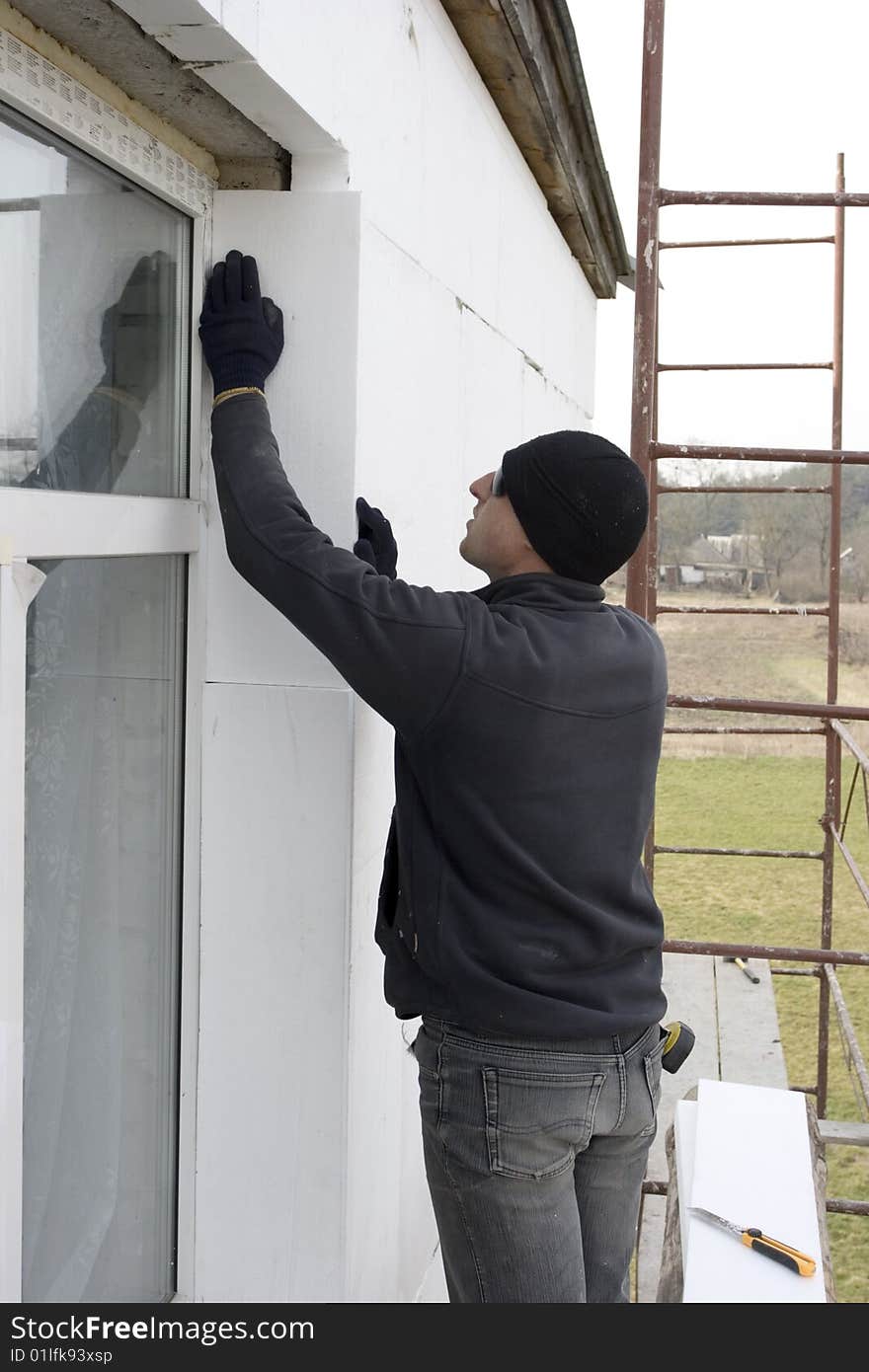 Builder glue polystyrene the plate on wall of the building