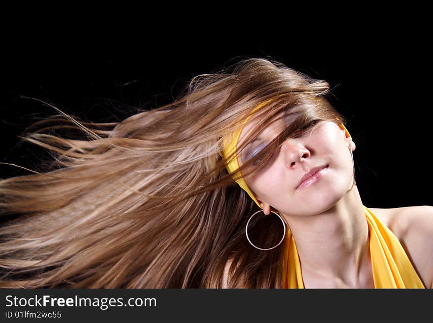 Beautiful young girl with magnificent hair on a black background