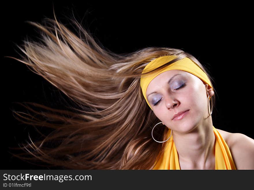 Beautiful young girl with magnificent hair on a black background