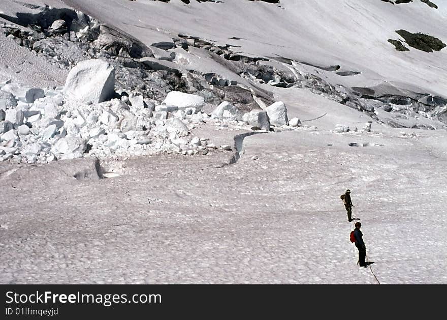 Climbers traversing crevassed glacier