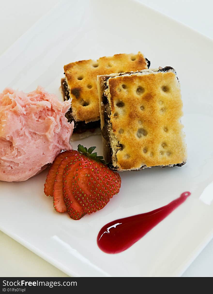 A fruit desert with ice cream and a strawberry.