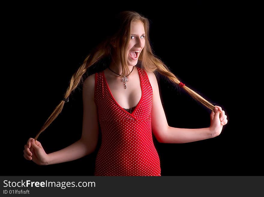 Laughing woman in a red dress holding a hair on a black background. Laughing woman in a red dress holding a hair on a black background