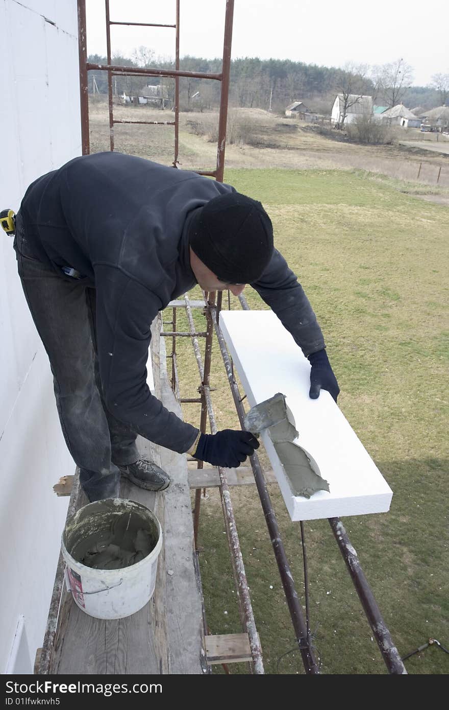 Master glue polystyrene the plate on wall of the building. fixing of the mortar on polystyrene plate