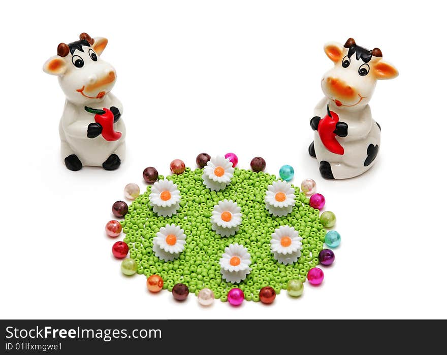 Two ceramic cows and a flower meadow from beads