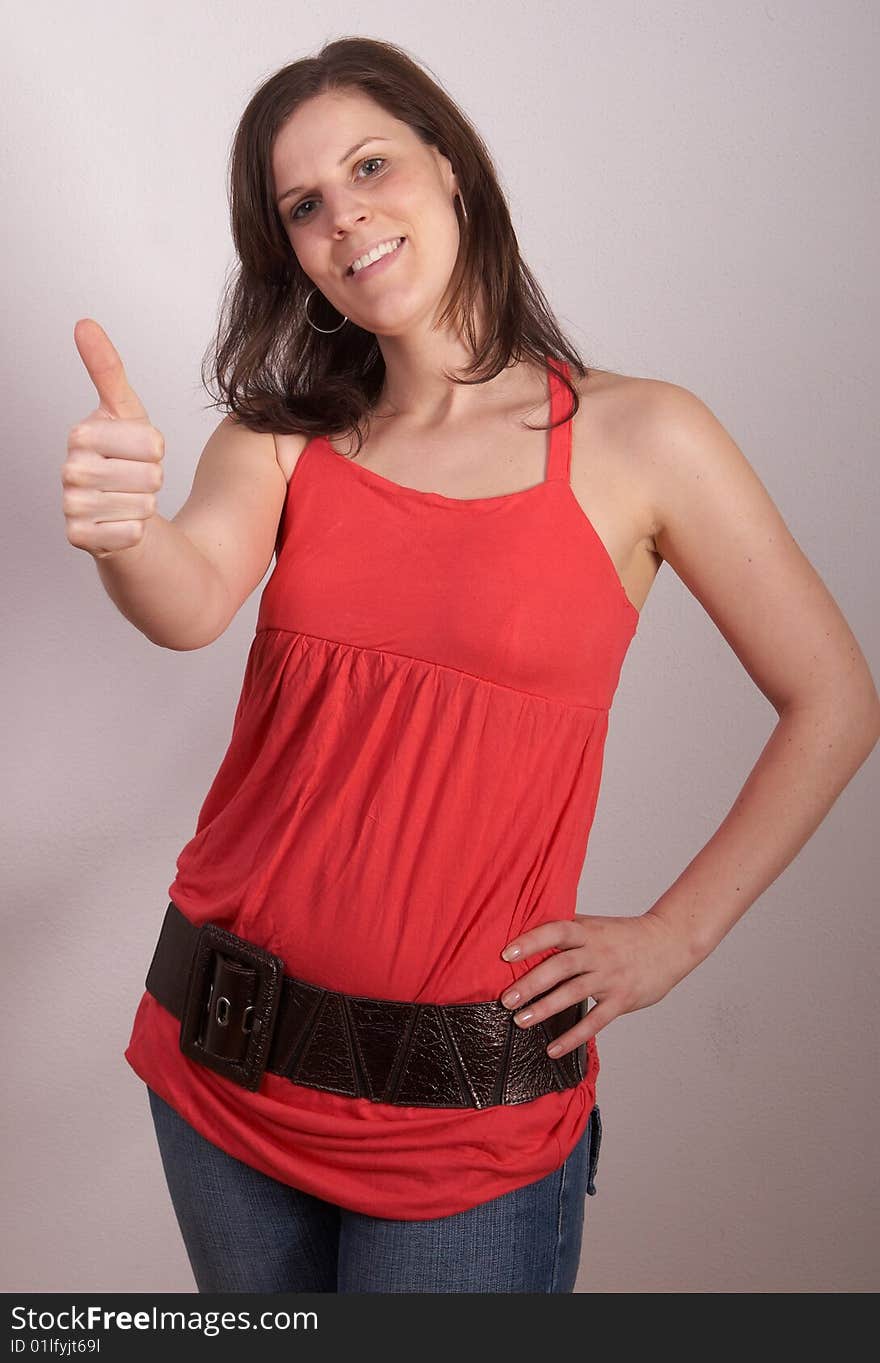 Young woman is showing a thumbs up sign. Young woman is showing a thumbs up sign.