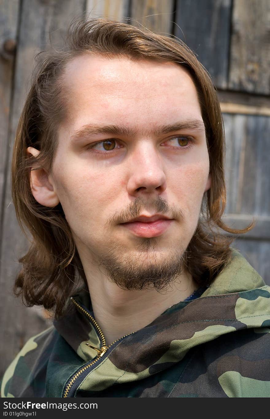 A portrait close-up of the young man with long hair and small beard. A portrait close-up of the young man with long hair and small beard.