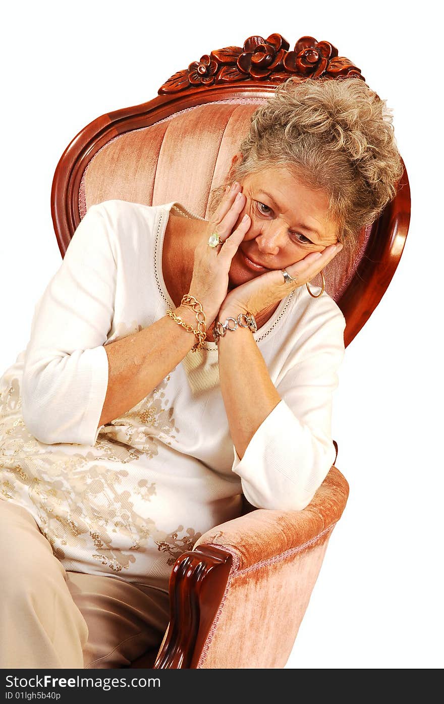 Senior woman sitting in an pink armchair with her head in her hands worrying over the future, on white background. Senior woman sitting in an pink armchair with her head in her hands worrying over the future, on white background.