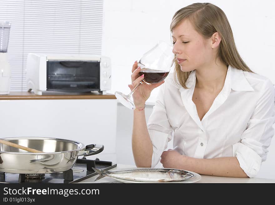 Women in kitchen with glass of wine. Women in kitchen with glass of wine