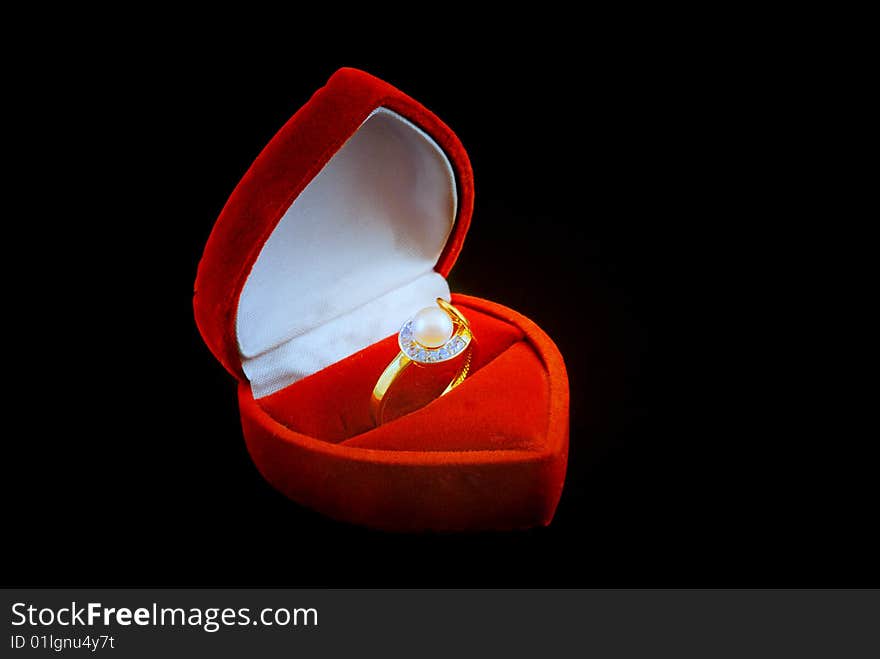 Pearl ring in fancy box isolated over black background.