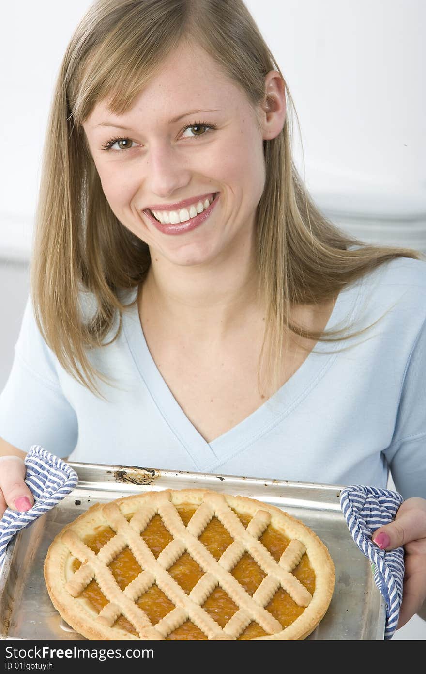 Beautiful woman in kitchen is making a cake