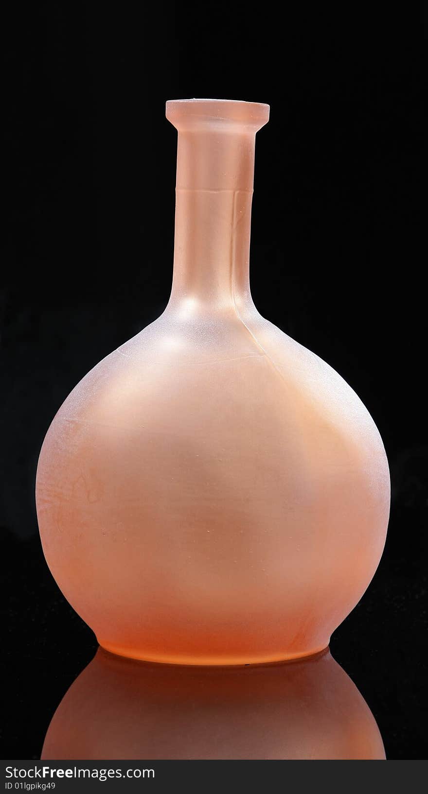 Pink round glass bottle on the black