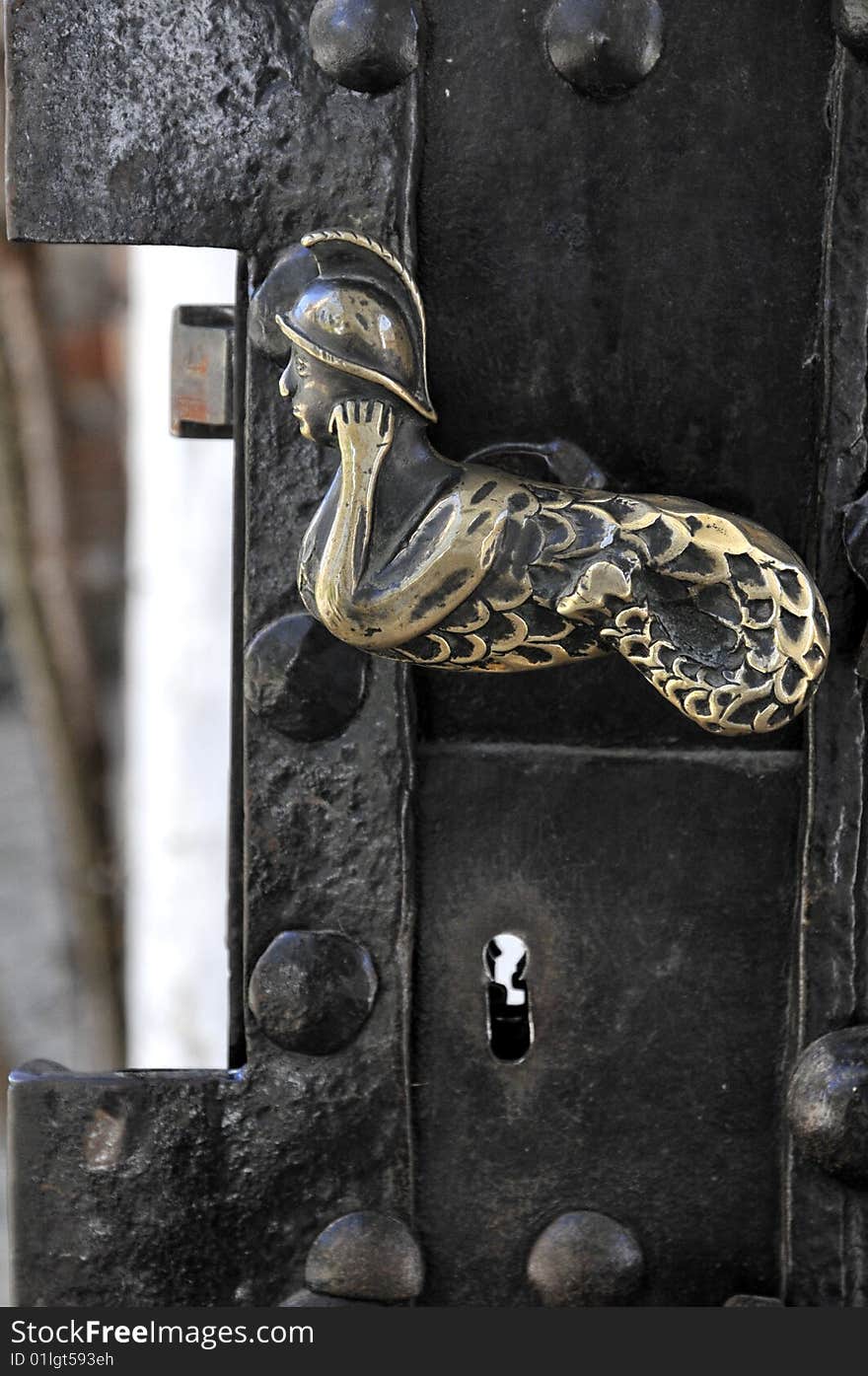 Old golden door handle on iron door