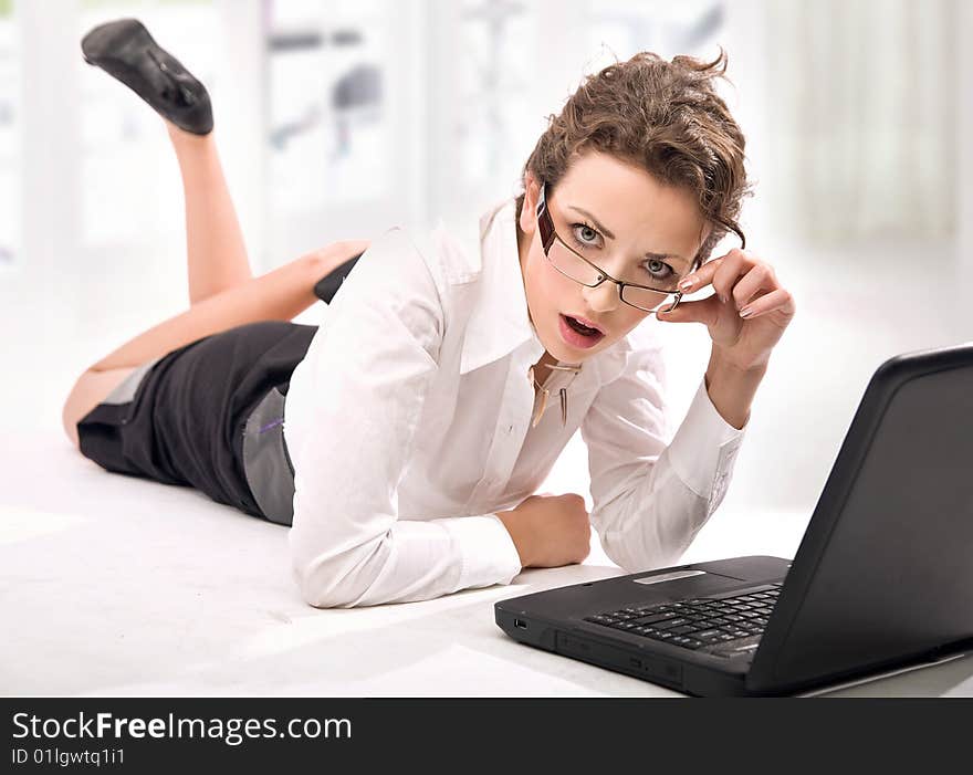 Happy young businesswoman with laptop looking attentively