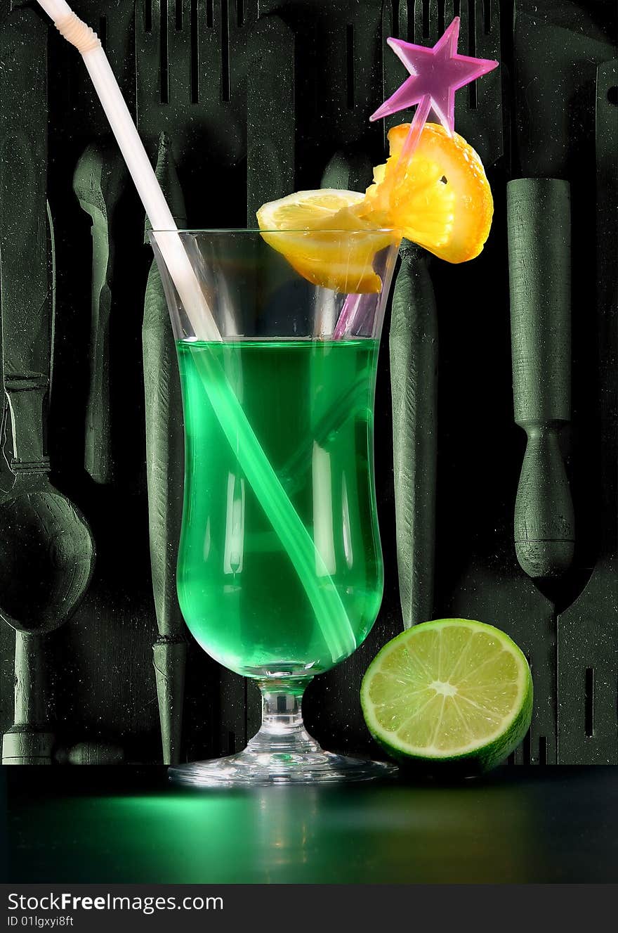 Green cocktail with lemon on dark background