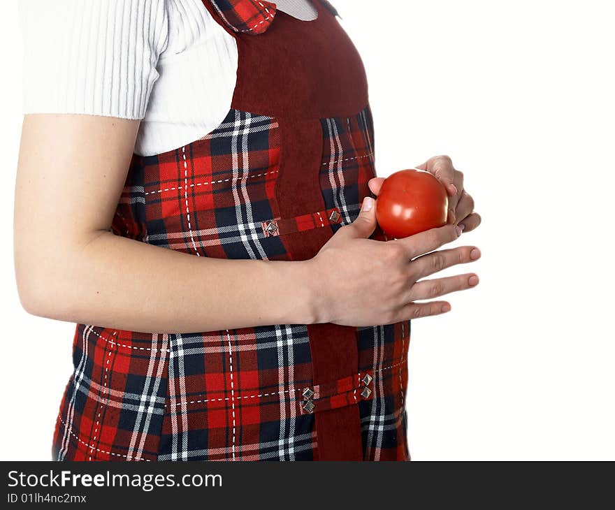 The pregnant woman holds a tomato in hands