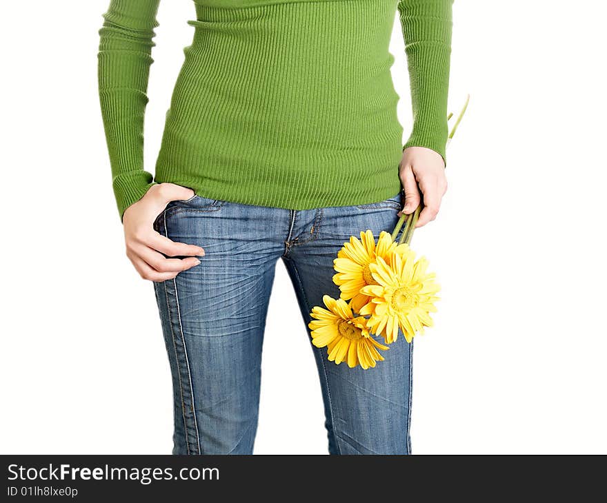 Yellow flowers in a hand of the harmonous girl in jeans