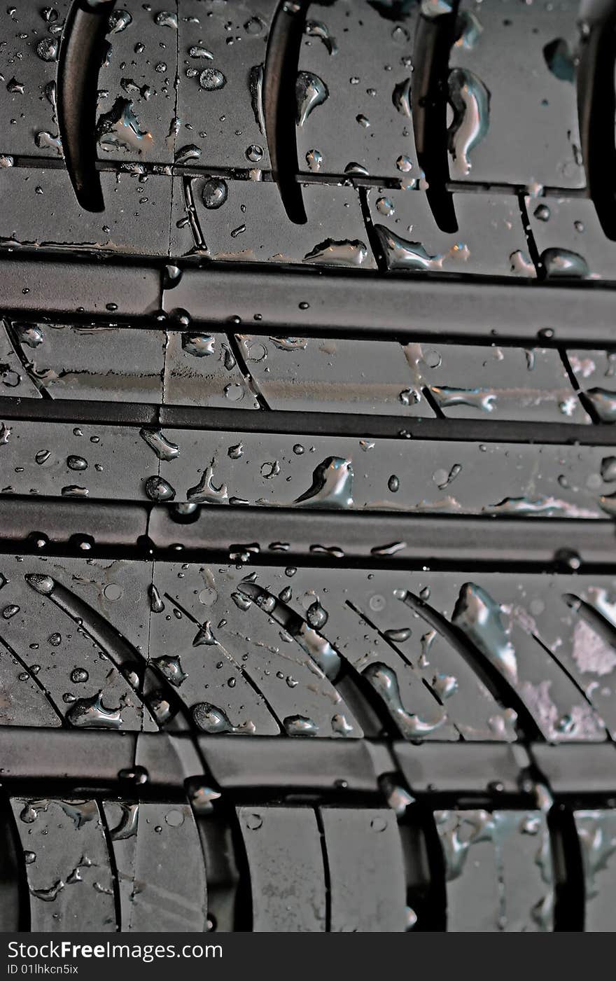 Close-up of car tire with with water drops to background