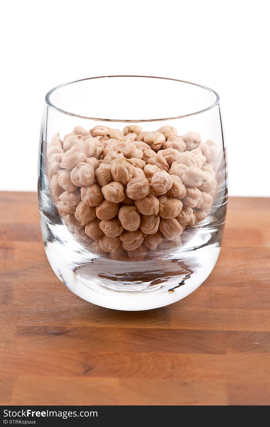 Chickpeas in Glass on wooden table, white background